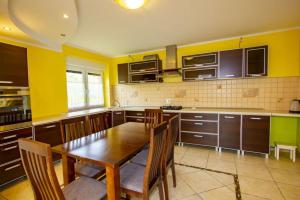 グジボボにあるVilla Arubaの木製テーブルと黄色の壁が備わるキッチン