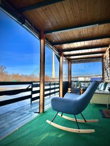 a blue chair on a porch with a bridge in the background at Splav Cilim House in Belgrade