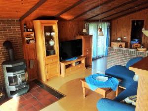 a living room with a blue couch and a stove at Freistehendes Ferienhaus in Rott mit eigenem Garten, schöner Weitblick, Klimaanlage, Sauna und Kamin in Extertal