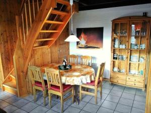 a dining room with a table and chairs and a staircase at Gemütliches Ferienhaus Alissa für 5 Personen mit Sauna und Kaminofen von Privat im Ferienpark Extert in Extertal