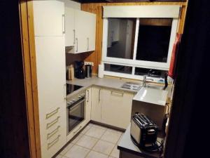 a small kitchen with white cabinets and a sink at Gemütliches Ferienhaus Alissa für 5 Personen mit Sauna und Kaminofen von Privat im Ferienpark Extert in Extertal