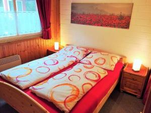 a bed in a room with two lamps on tables at Gemütliches Ferienhaus Alissa für 5 Personen mit Sauna und Kaminofen von Privat im Ferienpark Extert in Extertal +12 photos