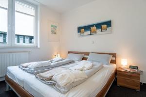 a bedroom with a large bed with white sheets at Strandpark-Grossenbrode-Haus-Moewennest-Wohnung-2 in Großenbrode
