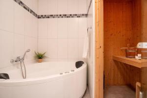 a white bath tub in a bathroom with a sink at Strandpark-Grossenbrode-Haus-Moewennest-Wohnung-2 in Großenbrode +12 photos