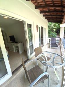 a patio with a table and chairs and a television at Hotel Mercedes in Ilhabela
