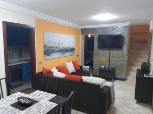 a living room with a couch and a television at Frataga Home in Playa Honda