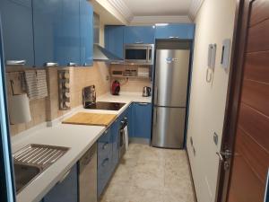 a kitchen with blue cabinets and a stainless steel refrigerator at Frataga Home in Playa Honda