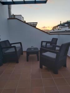 three chairs and a coffee table on a balcony at Frataga Home in Playa Honda