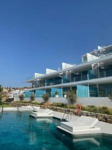 una piscina con sillas frente a un edificio en Med Two luxury apartment with sea view, en Fuengirola