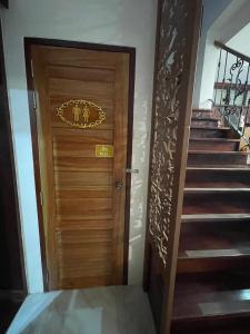 uma porta de madeira com uma placa ao lado de uma escada em โมเมนต์ แอ๊ท ริมโขง em Chiang Khan