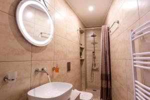 y baño con lavabo, espejo y ducha. en STAMOS Apartment airport en Spáta