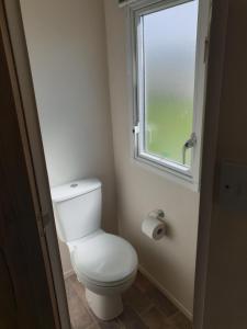 ein Bad mit einem weißen WC und einem Fenster in der Unterkunft Our Happy Place! in Weymouth