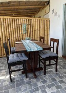 a wooden table with two chairs and a wooden fence at Departamento con vista al mar y piscina compartida in Máncora