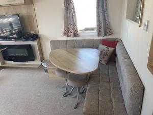 ein Wohnzimmer mit einem Sofa, einem Tisch und einem TV in der Unterkunft Our Happy Place! in Weymouth