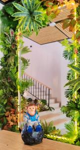 a doll sitting on a rock in a room with plants at Trip Monkey del Río in San Gil