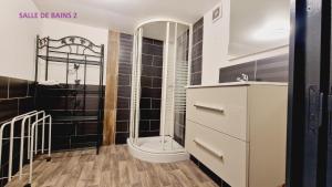 a bathroom with a shower with black tiled walls at Revauche et spa in Fresse-sur-Moselle +13 photos