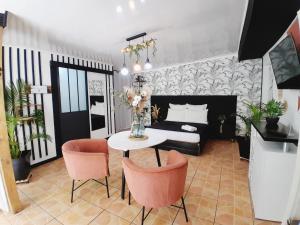 een slaapkamer met een bed en een tafel en stoelen bij The Secret Motel 7 Salazie à 15 min d'hell bourg in Salazie