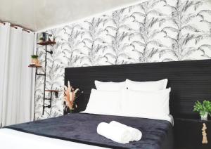 een slaapkamer met een bed met zwart en wit behang bij The Secret Motel 7 Salazie à 15 min d'hell bourg in Salazie
