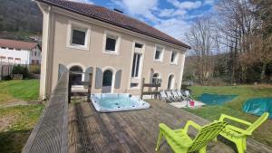 una casa con vasca idromassaggio e sedie su una terrazza di Maison de maître & spa a Cornimont