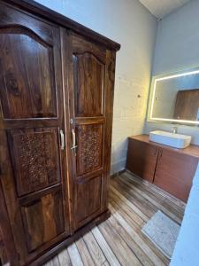 y baño con armario de madera y lavabo. en The Rajgharana Resort en Jhunjhunūn