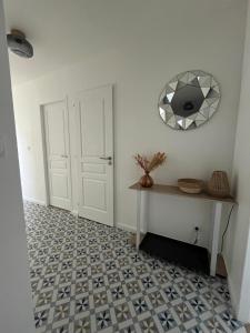 korytarz z białymi drzwiami i podłogą wyłożoną kafelkami w obiekcie Appartement Cosy et Confortable w mieście Saint-Genis-Laval