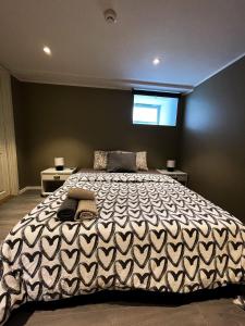 a bedroom with a large bed with a black and white blanket at Solsiden Modern stay: King Beds, Private Entry in Trondheim