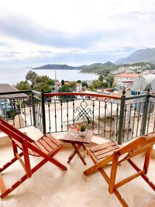 een balkon met 2 houten stoelen en een tafel bij Çınarlar Apart Hotel KAŞ in Kas