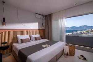 a bedroom with a large bed and a large window at Mistral Bay Hotel in Agios Nikolaos +54 photos