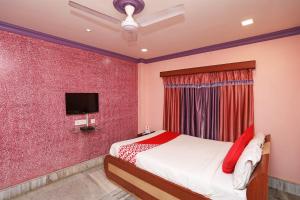 Un pat sau paturi într-o cameră la OYO Flagship Rainbow Guest House