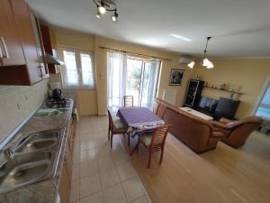 a kitchen and living room with a table and a couch at Va Zamete in Rijeka +16 photos