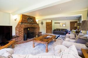 a living room with a couch and a fireplace at Gildridge in Chiddingly
