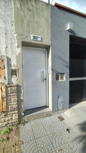 eine weiße Garagentür in einem grauen Gebäude in der Unterkunft Departamento tranquilo y luminoso in La Plata