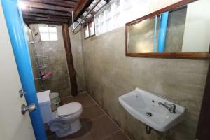La salle de bains est pourvue de toilettes blanches et d'un lavabo. dans l'établissement Green Feel Farmstay, à San Sai