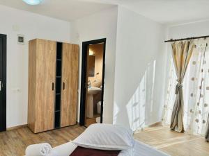 a white room with a bed and a bathroom at Elitegasthaus Moieciu A in Moieciu de Jos