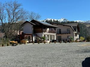 a large house with a large driveway in front of it at Elitegasthaus Moieciu A in Moieciu de Jos
