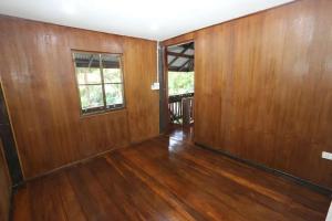 - un salon vide avec des murs en bois et du parquet dans l'établissement Green Feel Farmstay, à San Sai