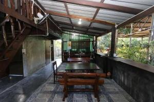 - une salle à manger avec une table et un banc dans l'établissement Green Feel Farmstay, à San Sai