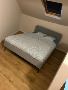 een bed in een kleine slaapkamer met een houten vloer bij Station 173 A Bruxelles-Charleroi-airport in Charleroi