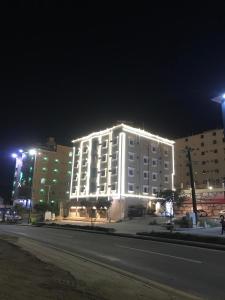 a large white building with lights on it at night at فندق وشقق ليالي الاحلام للشقق المخدومه in Baljurashi