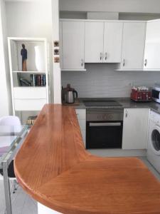 een keuken met een houten tafel in een keuken bij Zee zicht apartement Altea 2 pers in Caserío Capnegret