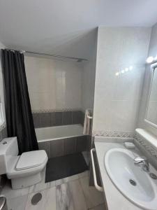 een badkamer met een wastafel, een toilet en een bad bij Zee zicht apartement Altea 2 pers in Caserío Capnegret