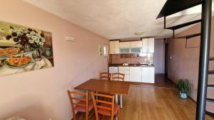 eine Küche und ein Esszimmer mit einem Tisch und Stühlen in der Unterkunft Vila Lena in Petrovac na Moru