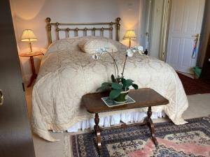 Un dormitorio con una cama con una mesa con flores. en The Gardens en Daventry
