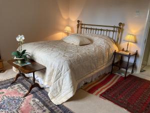 a bedroom with a bed and a table with two lamps at The Gardens in Daventry