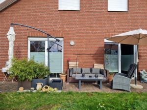 a patio with a couch and an umbrella at Premium Apartment in Sehnde
