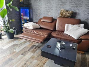 a living room with a brown couch and a table at Premium Apartment in Sehnde