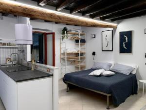 a bedroom with a bed and a kitchen with a sink at Appartamento Ca’ del Baffo @riocadelbaffo in Riomaggiore