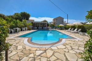 a pool with chairs and umbrellas in a resort at Moulinos Loft in Svoronata