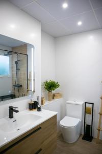 ein weißes Bad mit einem WC und einem Waschbecken in der Unterkunft Ramos Gardens in Baena