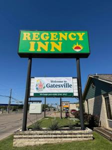 una señal para una posada de reinstalación frente a un edificio en Regency Inn en Gatesville